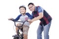 Dad helps his child to ride a bicycle Royalty Free Stock Photo