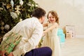 Dad hides behind his back a box with a gift for the baby daughter.