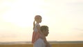 Dad with his daughter on his shoulders walks in sun. A child walks with daddy at sunset. Happy family is resting in park Royalty Free Stock Photo