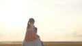 Dad with his daughter on his shoulders walks in sun. A child walks with daddy at sunset. Happy family is resting in park Royalty Free Stock Photo