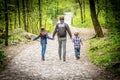 Dad with his kids walks from behind in the woods Royalty Free Stock Photo