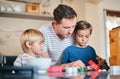 Dad and his little baker buddies. a young man baking with his two adorable sons at home. Royalty Free Stock Photo