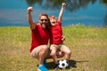 Dad with his little cute son are having fun and playing football on green grassy summer lawn. Football soccer sport Royalty Free Stock Photo