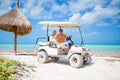 Young father and two little kids driving golf cart on a tropical beach Royalty Free Stock Photo