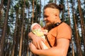 Dad holding his baby boy gently in his arms while trevelling in woods