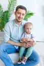 Dad holds a child in his arms and looks at the camera, the concept of a happy family, father`s Day, father-son relationship Royalty Free Stock Photo