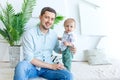 Dad holds a child in his arms and looks at the camera, the concept of a happy family, father`s Day, father-son relationship Royalty Free Stock Photo