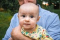 Dad holds his baby son in his arms close-up outdoors. Kid looking at the camera. Father and his newborn son Royalty Free Stock Photo