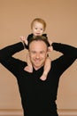 Dad holds a one-year-old daughter on a beige background. Fatherly love. Father`s day Royalty Free Stock Photo