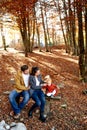 Dad hugging behind the waist of mom adjusting the headband on the head of a little girl on a bench Royalty Free Stock Photo