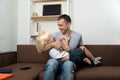 Dad hugging son at home on sofa. Family relationships