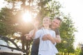 Dad hugs a boy standing near the car in the woods, the contour light. The concept of a family day Royalty Free Stock Photo