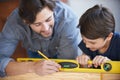 Dad, kid and woodwork pencil for project, bonding and building with safety gear. Father, son and carpenter for Royalty Free Stock Photo