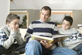 Dad and kids reading book Royalty Free Stock Photo