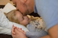 dad kisses his sick child on the forehead before bed. Father with tenderness and care kisses his daughter. the concept Royalty Free Stock Photo