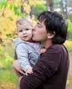 Dad kissing his son on autumn outdoor Royalty Free Stock Photo