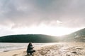 Dad with a little girl flying a kite sitting on the beach by the sea Royalty Free Stock Photo