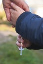 Dad and little son hold each other`s hand with a rosary