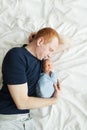 Dad is lying in bed with his newborn son. Royalty Free Stock Photo