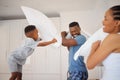 Dad, mom and child in pillow fight in bedroom with morning games, bonding or playful happy family in home. Mother Royalty Free Stock Photo