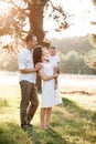 Dad, mom hugging son outdoors in the park. The concept of summer holiday. Mother`s, father`s, baby`s day. Family spending time Royalty Free Stock Photo