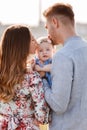 Dad and mom kissing little daughter outdoors at nature. The concept of summer holiday. Mother`s, father`s, baby`s day. Family Royalty Free Stock Photo