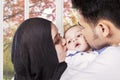 Dad and mom kissing their baby cheeks Royalty Free Stock Photo