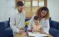 Dad, Mom and little daughter drawing with colorful pencils on paper happy smiling.Young family spend free time together in living Royalty Free Stock Photo