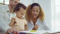 Dad, Mom and little daughter drawing with colorful pencils on paper happy smiling.Young family spend free time together in living Royalty Free Stock Photo