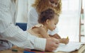 Dad, Mom and little daughter drawing with colorful pencils on paper happy smiling.Young family spend free time together in living Royalty Free Stock Photo