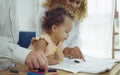 Dad, Mom and little daughter drawing with colorful pencils on paper happy smiling.Young family spend free time together in living Royalty Free Stock Photo