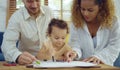 Dad, Mom and little daughter drawing with colorful pencils on paper happy smiling.Young family spend free time together in living Royalty Free Stock Photo