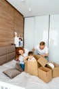 Dad mom and little son play in the bedroom with paper boxes Royalty Free Stock Photo