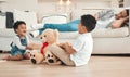 Dad needs a break. two siblings fighting over a teddy on the floor while their dad sleeps on the couch at home.