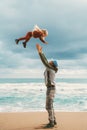 Dad playfully throwing child in the air family lifestyle father and daughter together having fun outdoor walking on the beach Royalty Free Stock Photo