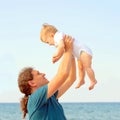 Dad playing with baby on the beach. Royalty Free Stock Photo