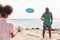 Dad playing frisbee with child on the beach Royalty Free Stock Photo