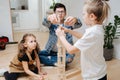 Dad and children playing building high tower from wooden blocks Royalty Free Stock Photo