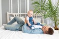 Dad plays on the bed with baby son, happy fatherhood Royalty Free Stock Photo