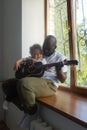 Dad plays guitar to son song, Afro Amercans Royalty Free Stock Photo