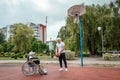 Dad plays with his disabled son on the sports ground. Concept wheelchair, disabled person, fulfilling life, father and son,