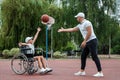 Dad plays with his disabled son on the sports ground. Concept wheelchair, disabled person, fulfilling life, father and son,