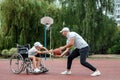 Dad plays with his disabled son on the sports ground. Concept wheelchair, disabled person, fulfilling life, father and son,