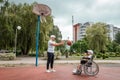 Dad plays with his disabled son on the sports ground. Concept wheelchair, disabled person, fulfilling life, father and son,