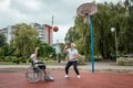 Dad plays with his disabled son on the sports ground. Concept wheelchair, disabled person, fulfilling life, father and son,