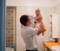 dad plays with newborn son and tosses him up in the bathroom. water procedures Royalty Free Stock Photo