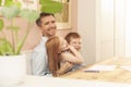 Dad, pre-teen boy and young girl laughing during homeschooling due to the coronavirus lockdown.