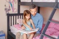 Dad reading book to little daughter girl. Happy family of two sitting on a bed in bedroom. Smiling father and child at home Royalty Free Stock Photo