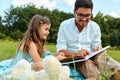 Dad Reading Child A Book In Park. Father And Daughter In Nature