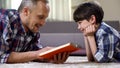 Dad reading son exciting fantasy book, imagination and creativity, leisure time